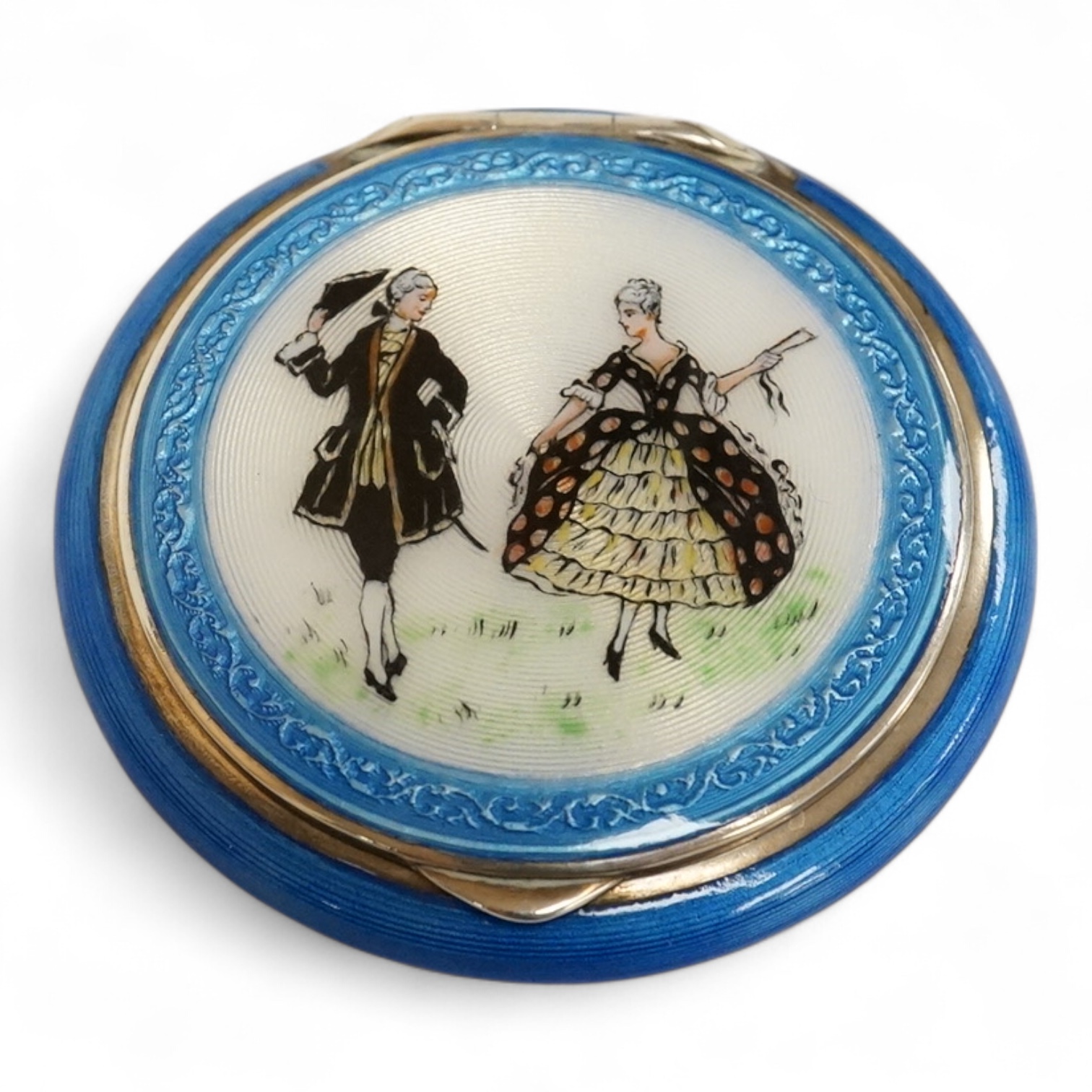 A George V silver and enamelled circular compact, the cover depicting a lady and gentleman, import marked for P.H. Vogel & Co, London, 1924, diameter 51mm.